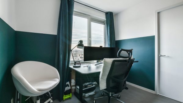 a room with two chairs and a desk in front of a window that looks out onto the cityscape