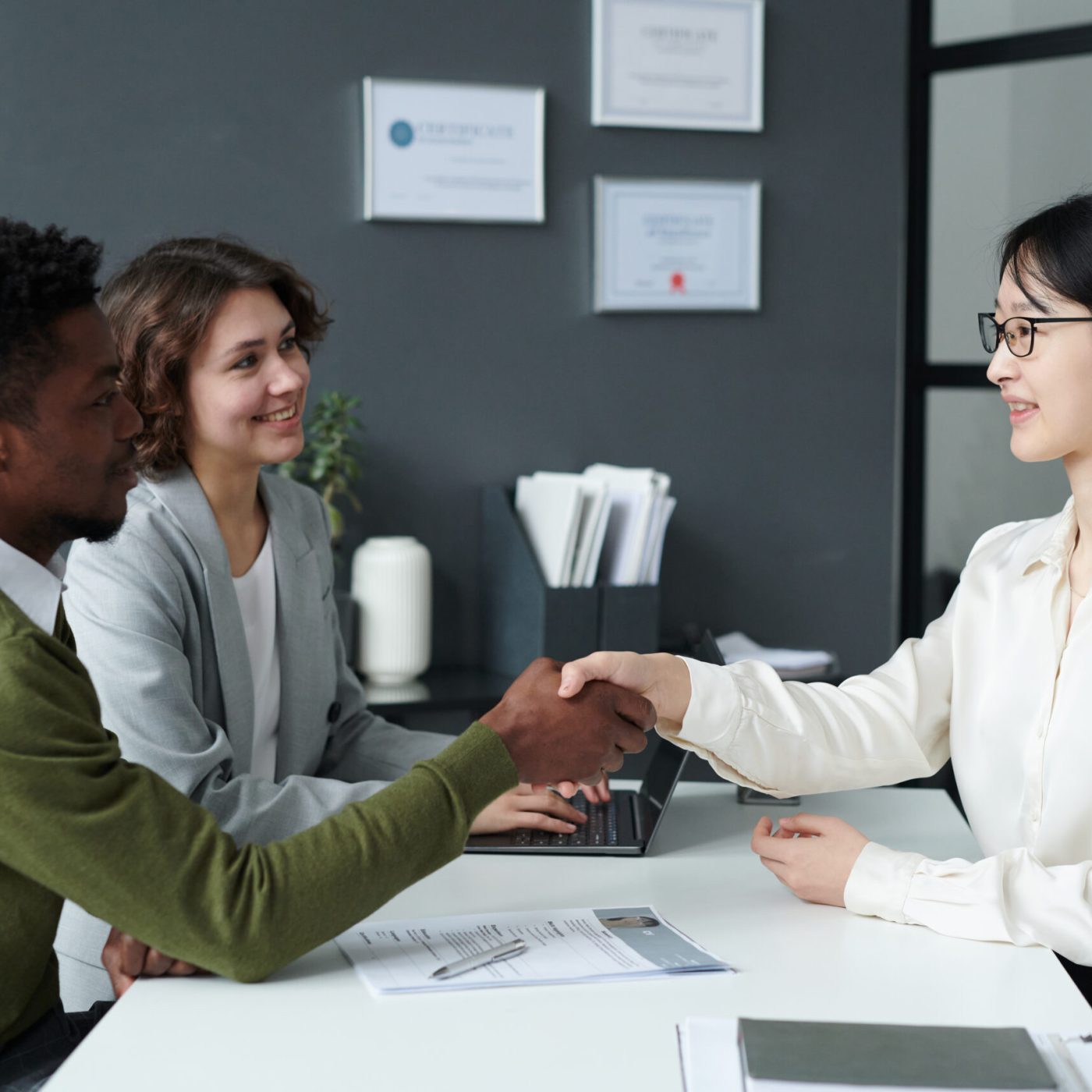 African American employer shaking hands with candidate during their meeting in modern office