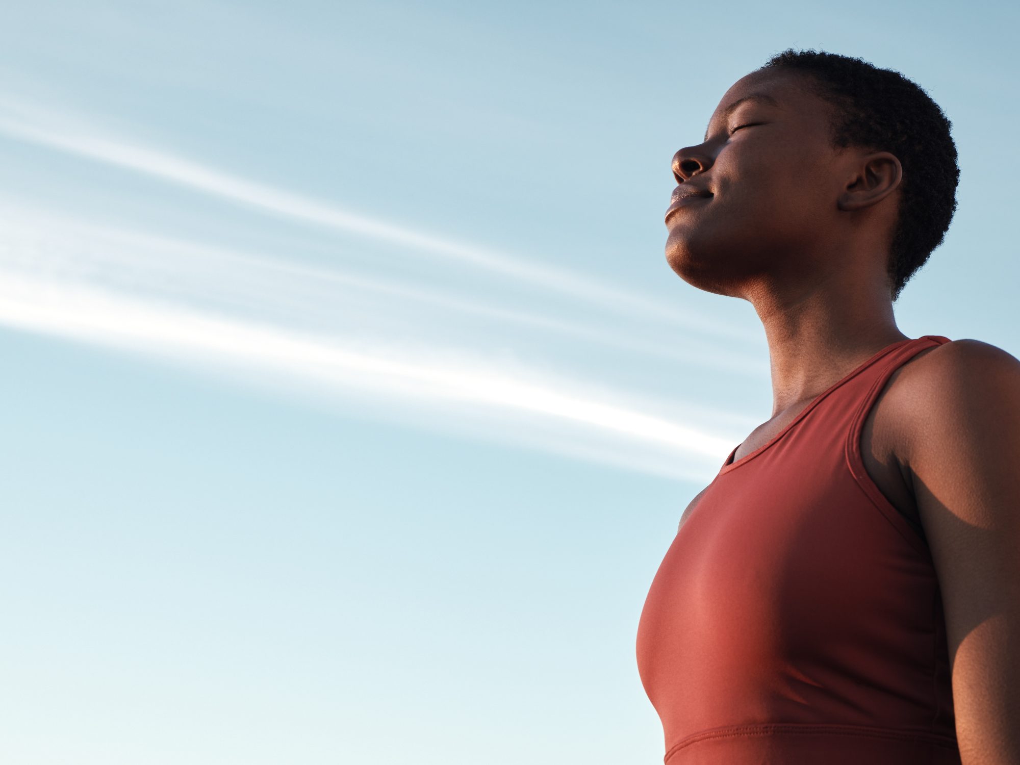 Fitness, breath and mockup with a sports black woman taking a break outdoor against a clear blue sk.