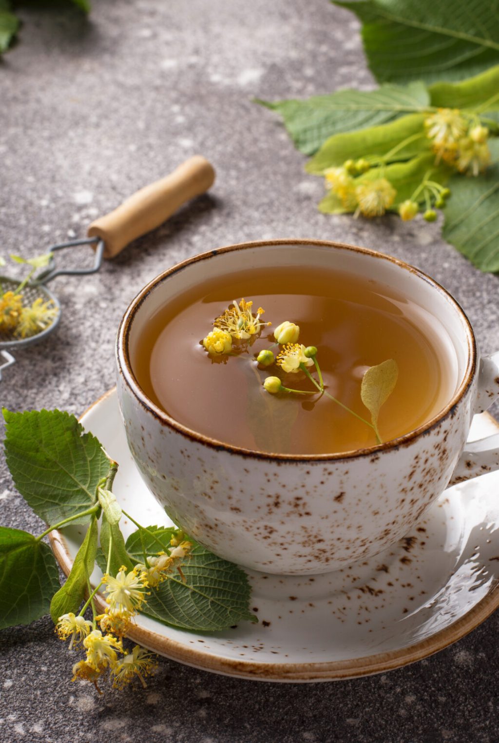 Healthy hot linden tea in cup on grey background