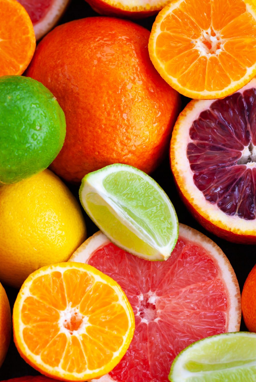 Close up of fresh juicy citrus fruits - oranges, mandarins, lemons and limes, top view